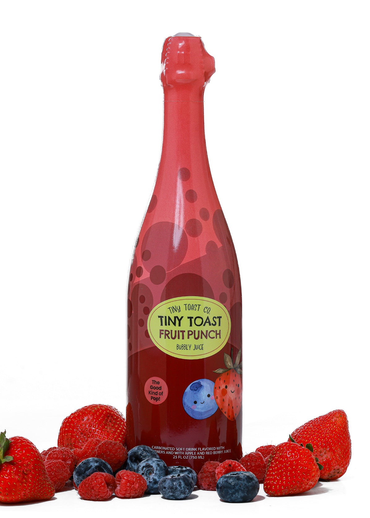 A bottle of Tiny Toast Fruit Punch Bubbly Juice centered on a white background, surrounded by fresh strawberries, raspberries, and blueberries at the base. The bottle is red with dark red polka dots and a yellow-green oval label reading 'Tiny Toast Fruit Punch Berry Juice'.